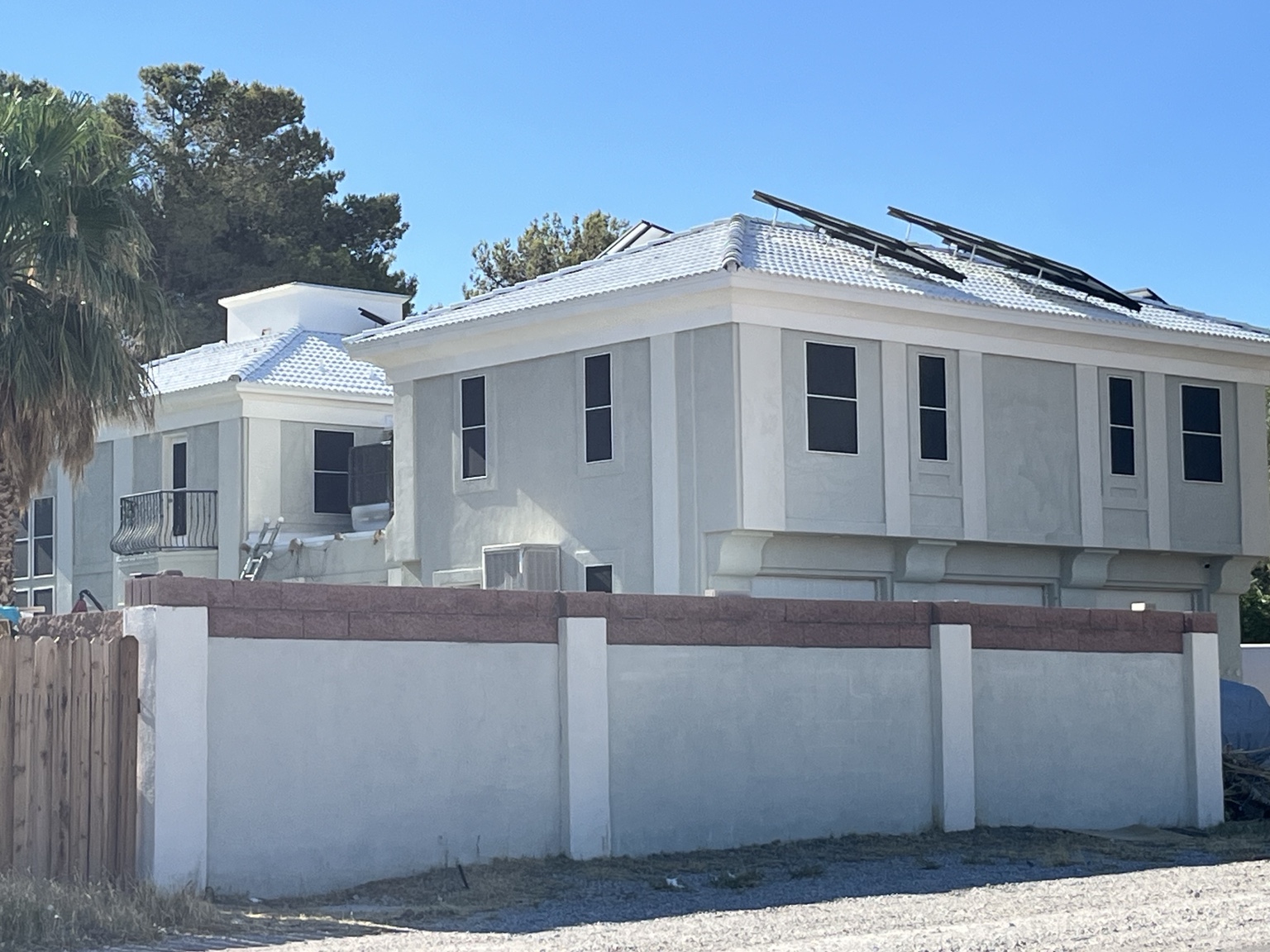 White-coated residential roof with solar panels