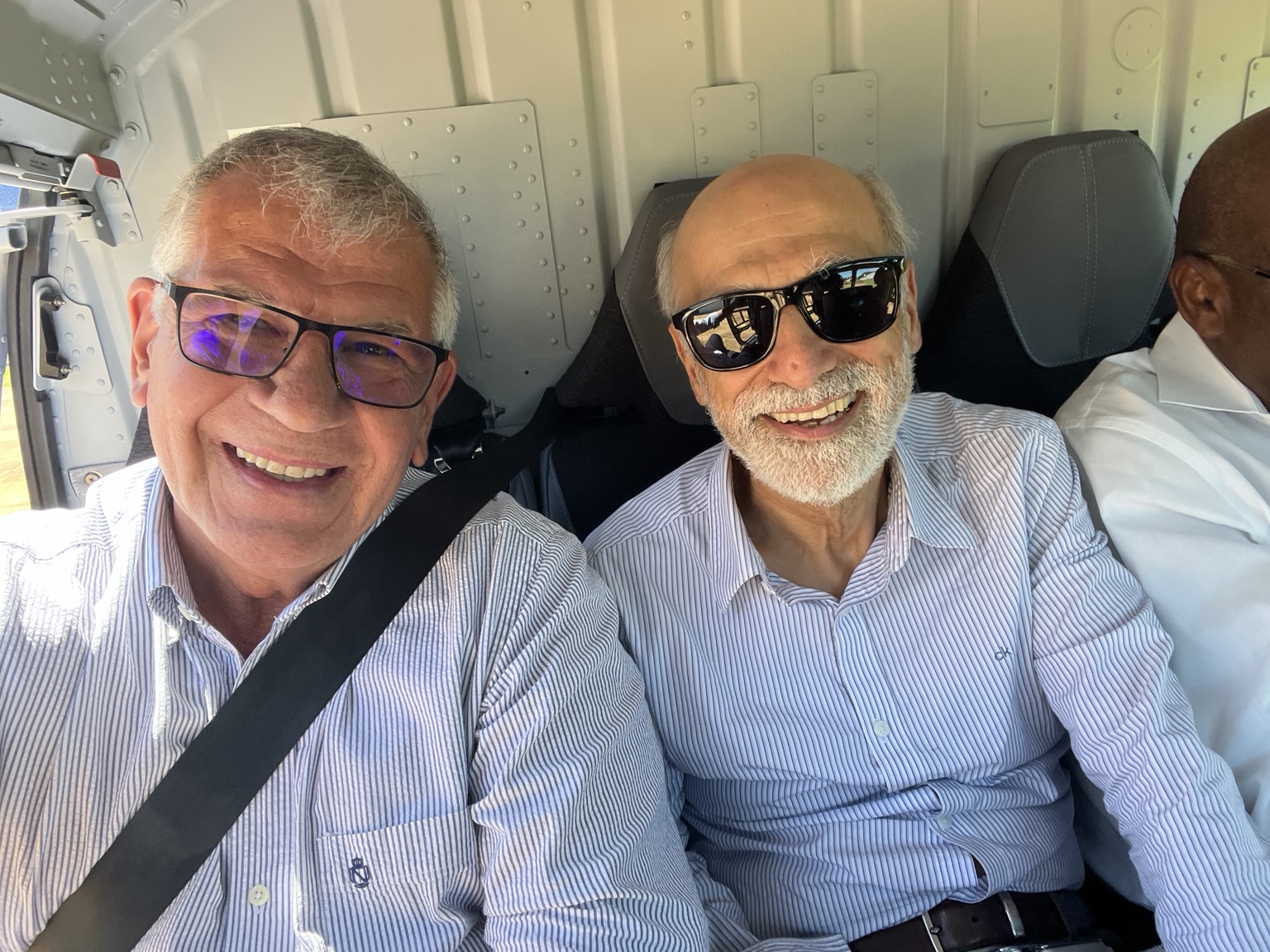 Two colleagues seated together inside an aircraft